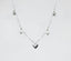 a silver heart necklace on a white background
