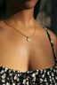 A close up of a woman wearing a necklace