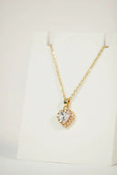 Gold heart-shaped pendant necklace with central crystal and smaller stones in 18k gold jewelry for luxury love gifts