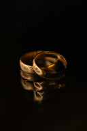 two wedding rings sitting on top of a table