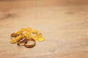 18k gold wedding rings with coin accents on wood