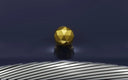 a golden object sitting on top of a metal structure