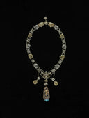 An ornate multi-gemstone necklace with gold and silver-toned links featuring intricate filigree in fine jewelry style.