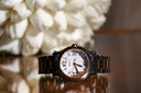 A sleek Chopard watch with white dial, roman numerals, and black rose gold bracelet for fine jewelry lovers.