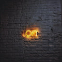 a brick wall with a neon sign on it