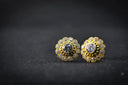Gold-toned stud earrings with a central clear gemstone and halo of smaller stones from eleven art gold jewelry collection
