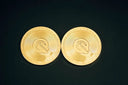 a pair of gold coin sitting on top of a black table