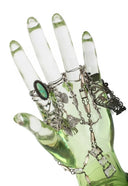 A translucent green glass hand displaying fine silver-toned jewelry including rings and chains for engagement rings.