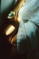 Delicate white lace dress with floral patterns near engagement rings