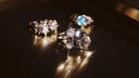 A silver star-shaped engagement ring with central diamond and moonstone accent inspired by royal jewels and 18k gold jewelry