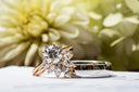 A rose gold engagement ring with a central round diamond and marquise cuts paired with a silver band, perfect gold jewelry in 18k gold