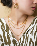 Gold-toned layered necklaces featuring sleek snake chain, twisted rope, and flat link designs in 18k gold fine jewelry.