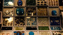 A collection of colorful faceted gemstones displayed in white trays highlighting fine jewelry and hope diamond origins.