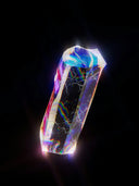A translucent prism-shaped crystal with iridescent rainbow reflections featured in the enigmatic world of gold rings and fine jewelry