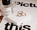 A pair of rose gold hoop earrings with minimalist design resting on a white box for art gold jewelry care tips