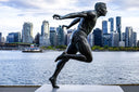 Bronze statue of a male runner in mid-stride showcasing dynamic motion and detailed musculature in fine jewelry context