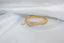 a gold ring on a white surface
