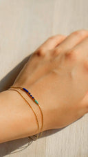 A delicate gold chain bracelet with vibrant blue and green beads showcasing fine gold jewelry from Art Gold.