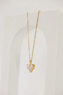 A delicate diamond heart necklace in 18k gold jewelry featuring clear faceted crystals in a golden metal frame