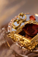 A golden ornate mirror frame with intricate filigree detail reflecting engagement rings at everett jewelry store.