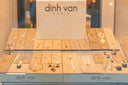 Gold and silver fine jewelry including necklaces earrings bracelets and rings displayed on beige trays in dinh van paris store window