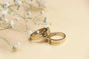 Gold wedding bands with intricate geometric patterns and diamonds crafted as 18k gold jewelry for engagement rings.