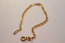 Gold-colored figaro link bracelet with secure clasp crafted from 18k gold fine jewelry for elegant styling.