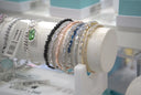 A collection of delicate sparkling birthstone bracelets in various colors displayed on a white mannequin arm at everett jewelry store