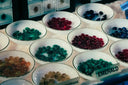White ceramic bowls with translucent gemstone-like beads in vibrant colors for art gold and fine jewelry designs
