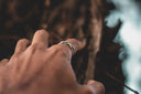 Intricate silver fine jewelry band ring on finger