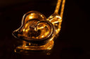 A gleaming 18k gold heart-shaped pendant with a central diamond showcases fine gold jewelry trends in 2026.