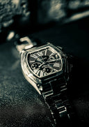 A sleek silver-toned Cartier watch with a rectangular case and black dial featuring roman numerals in fine jewelry.
