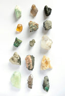 A collection of rare unpolished minerals in earthy tones highlighting raw materials for fine jewelry and gold rings.