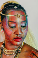 A woman wearing ornate art gold jewelry with a gold headpiece featuring a central pendant in local family business style