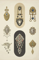 A vintage-style ornate brooch with black enamel, silver-toned metalwork, and red gemstones in fine jewelry design.