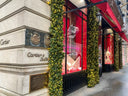 The cartier building facade with gold-embossed signage and festive greenery highlights fine jewelry in 18k gold designs