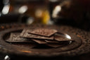 Dark brown intricately engraved chocolate squares on an ornate metal plate symbolizing timeless elegance for everett jewelry store.