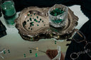 Antique silver tray with ornate scalloped edges and intricate floral detailing complementing engagement rings and gold jewelry.