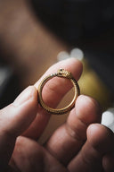 a person holding a gold ring in their hand