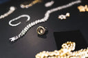 A gold jewelry ring with a round bezel-set stone surrounded by small diamonds featured in famous jewelry heists