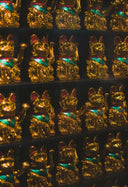 Golden meneki-neko figurines with teal collars and red ear tips complement personalized gold pendants and art gold jewelry trends