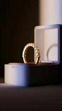 A gold ring sitting on top of a white box