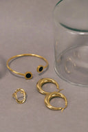 a pair of gold rings and a glass of water