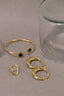 a pair of gold rings and a glass of water