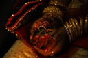 Hand with red henna, gold bangles holding royal jewels engagement ring