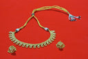 Art gold jewelry: gold necklace with circular designs and earrings on red background