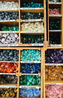 A vibrant collection of polished rare gemstones in wooden trays for art gold jewelry and gold jewelry designs.