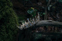 A delicate gold tiara with sparkling blue and clear crystals inspired by ancient civilizations in gemstone legends.