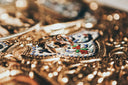 Two interlocking gold rings with beaded design on ornate enamel tray
