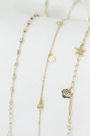 Three delicate gold jewelry necklaces with 18k gold chains featuring starfish and seashell charms for fine jewelry style